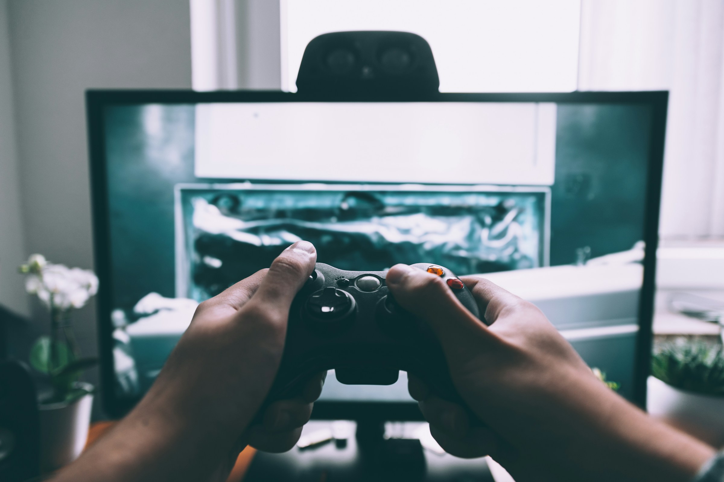 A player using a game controller in front of a screen