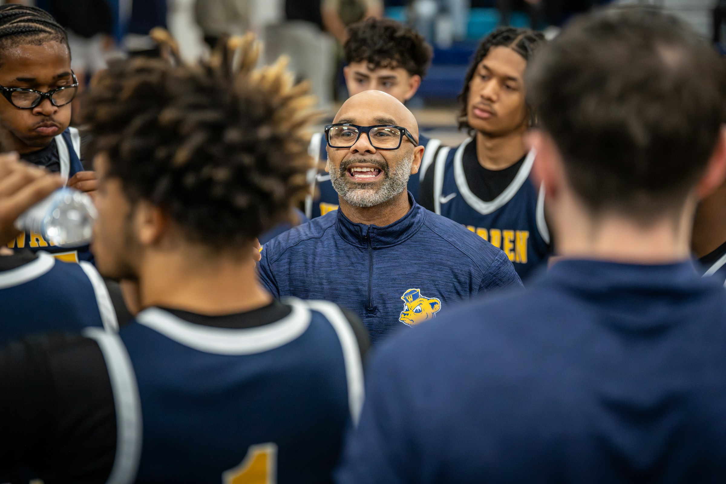 A coach giving instructions to players during a team huddle