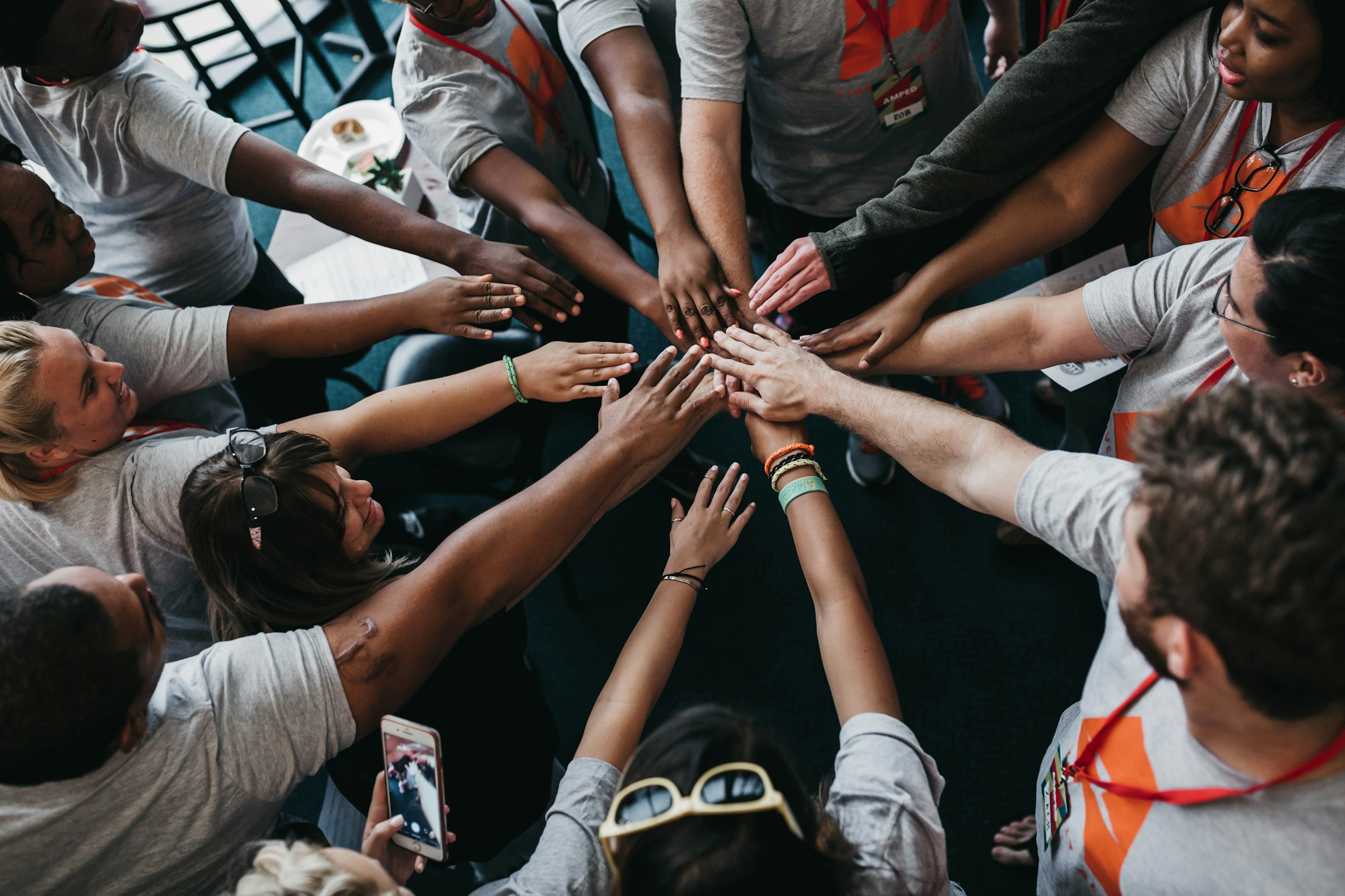 Team members with their hands gathered together in the middle